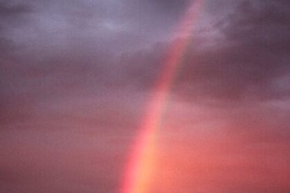 rainbow in cloudy sky at sunset