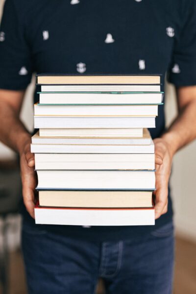 person holding stack of books